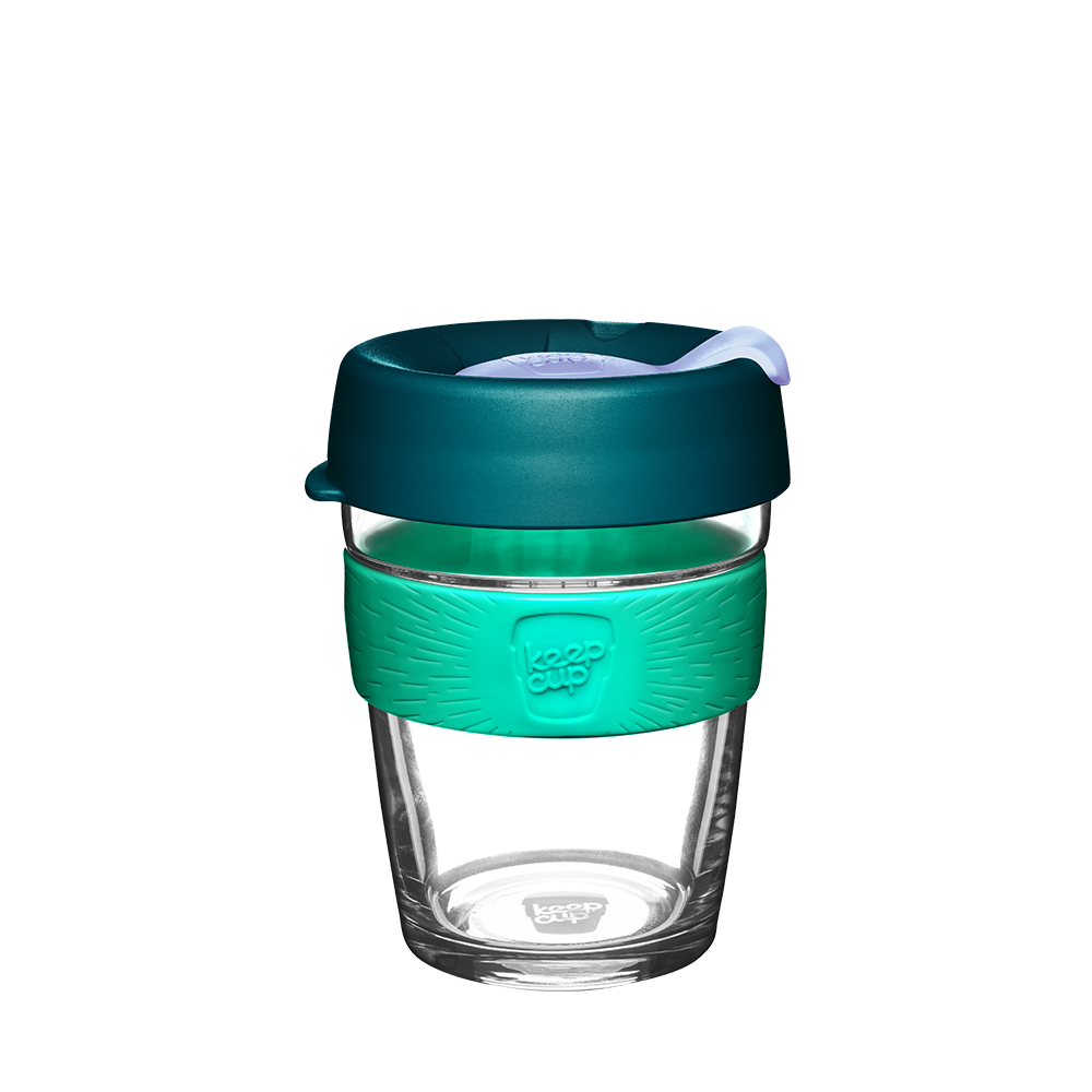 Clear glass reusable coffee cup with teal sleeve and lid on a white background