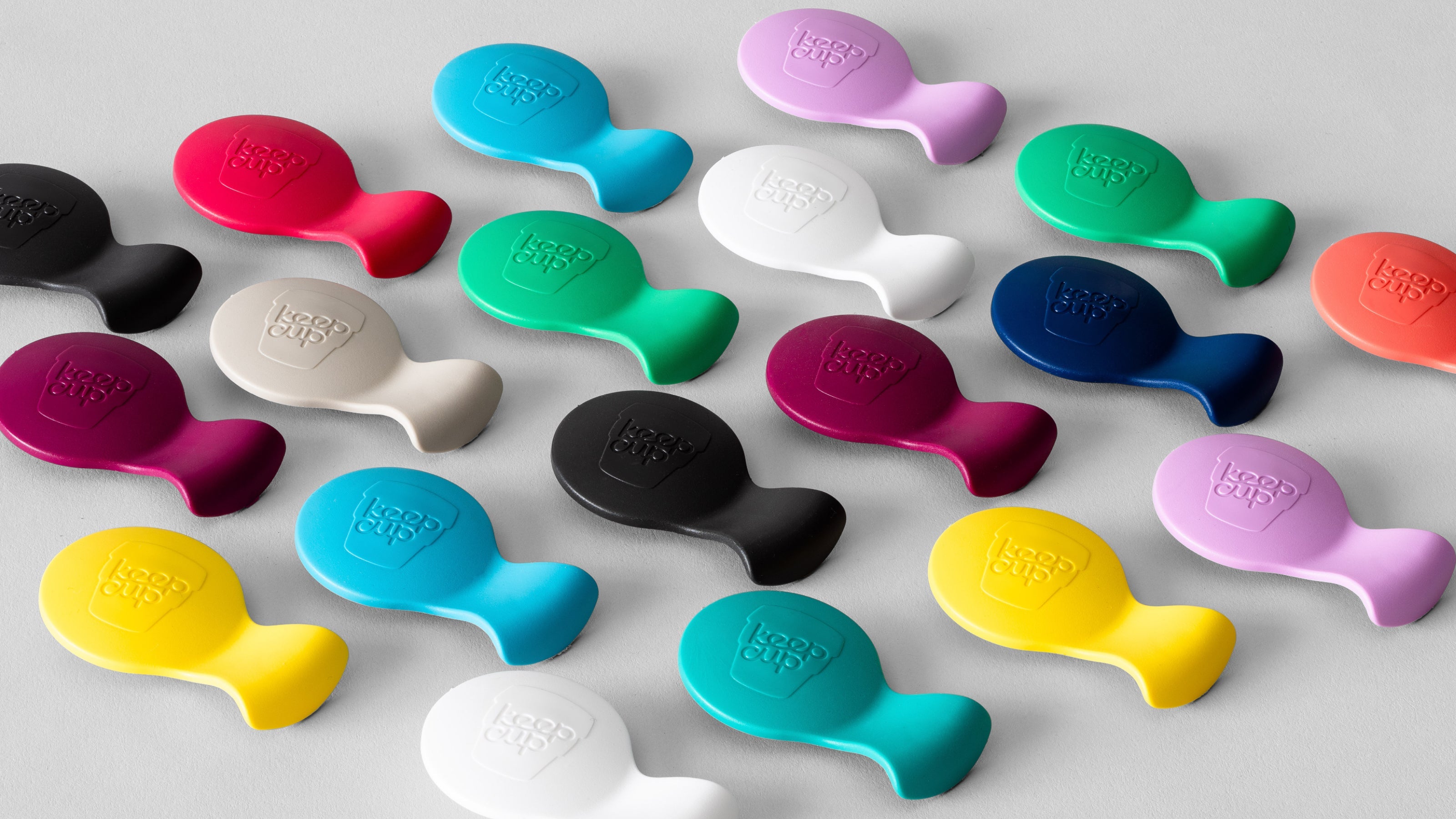 Colourful silicone phone grips in various bright colours including yellow, blue, pink, green, black and white with embossed logo branding
