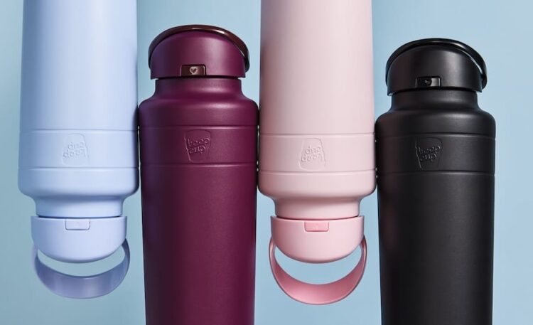 Four KeepCup reusable coffee cups in light blue, burgundy, pink and black colours with matching lids, displayed against blue background