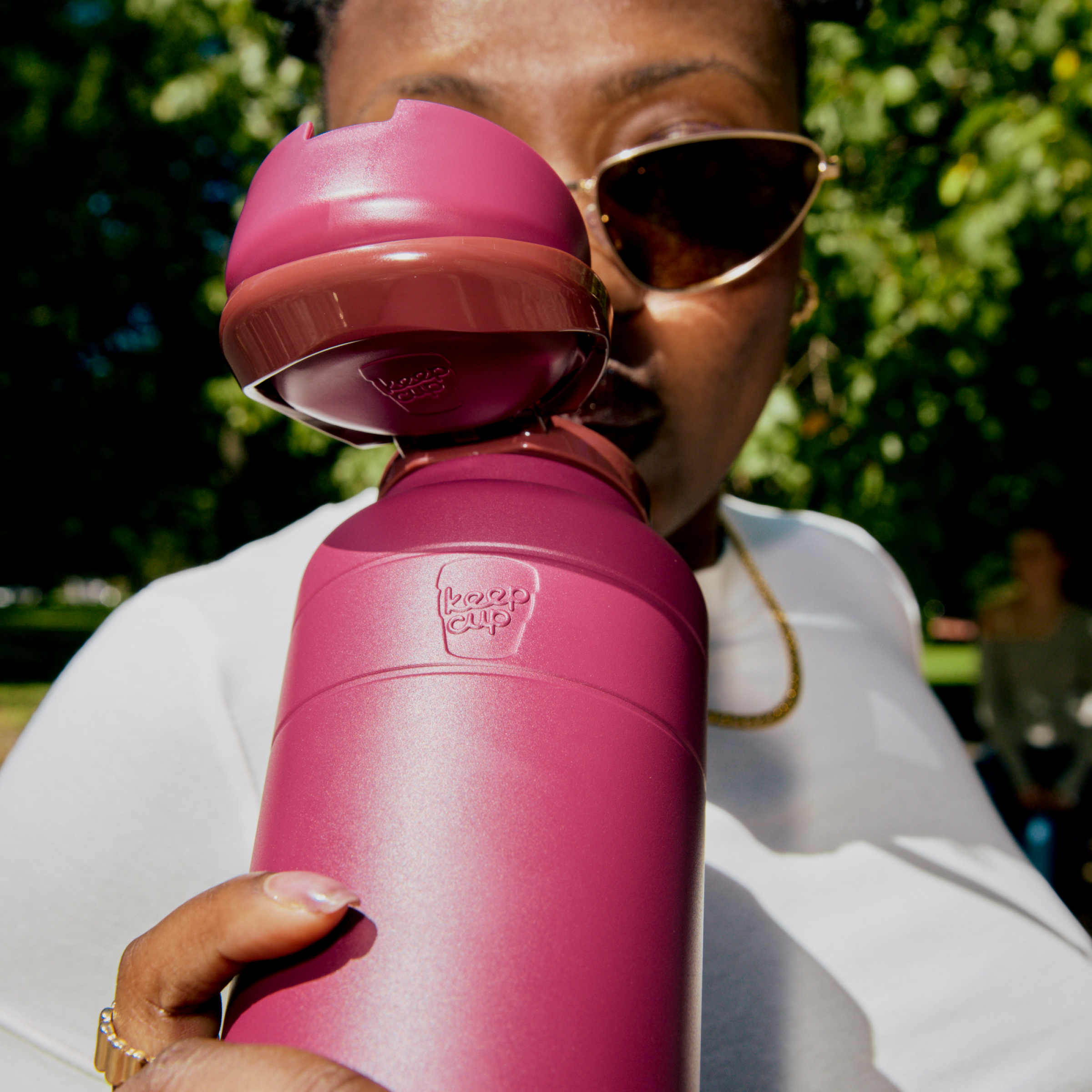 Person holding a mulberry water bottle with a unique design outdoors