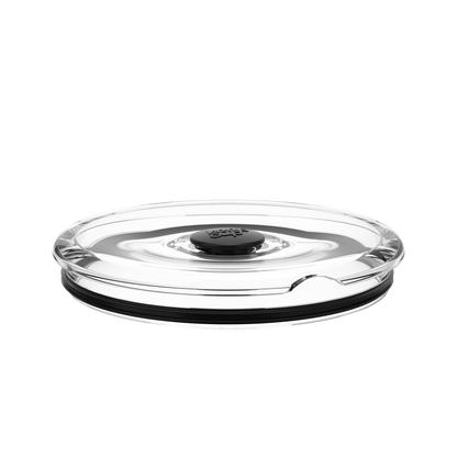 Go Bowl Flat Lid in Black, shown from a low side angle against a white background, featuring a clear plastic lid with a central black vent button and black silicone seal ring around the base.