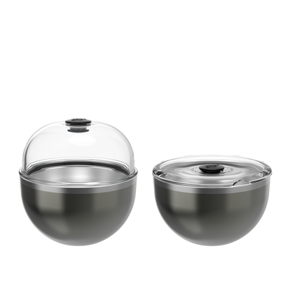 Two grey stainless steel bowls with clear glass lids and black handles, one dome-shaped lid raised, one flat lid closed