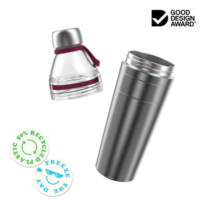 KeepCup Helix Bottle Clear Top 770ml shown as an exploded view with the clear plastic top section featuring a stainless steel cap and burgundy carry loop separated from the black stainless steel base. Badges highlight 50% recycled plastic and a freezable component, alongside a Good Design Award logo.
