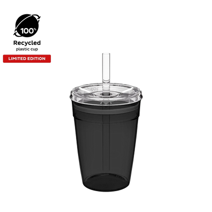 KeepCup Cold Cup Original M 12oz in Recycled Black, shown from a front angle against a white background. The translucent black cup features a clear lid with straw, with badges highlighting it is made from 100% recycled plastic and is a limited edition.