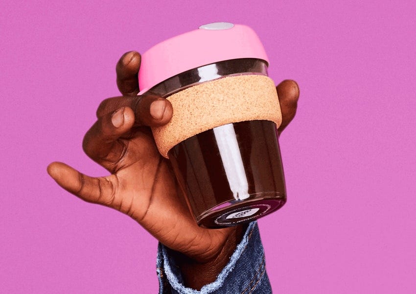 KeepCup a Living Wage employer, female founder and equal opportunity workplace Hand holding pink KeepCup Brew Cork glass reusable cup on Neon Pink background