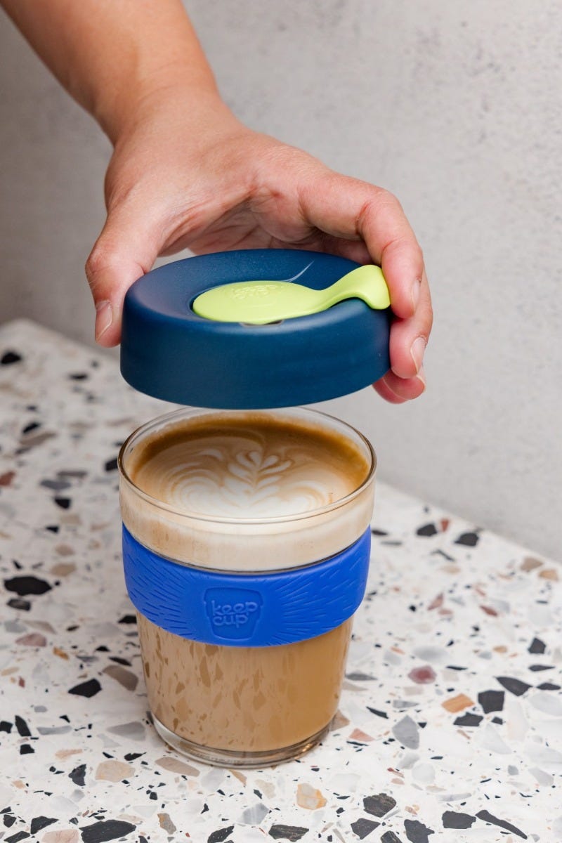 Woman holding KeepCup Sip & Chill Original Clear reusable cup with coffee and iced tea