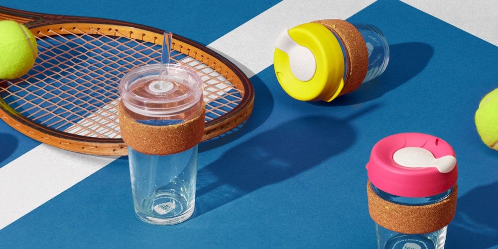 KeepCup Ace Cold Cup Cork and Brew Cork against tennis court with tennis balls and racquet